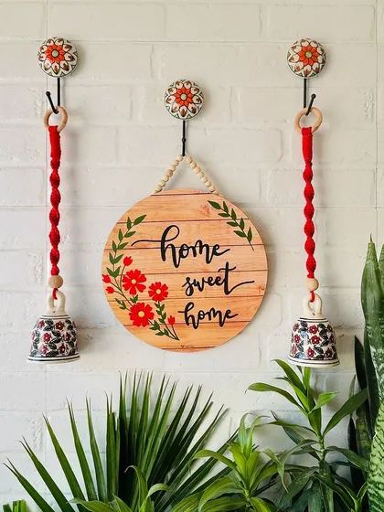 A beautiful wall setup featuring our 'Home Sweet Home' wooden sign and two red macrame ceramic bells. This combination creates a warm and inviting entrance, perfect for any home.