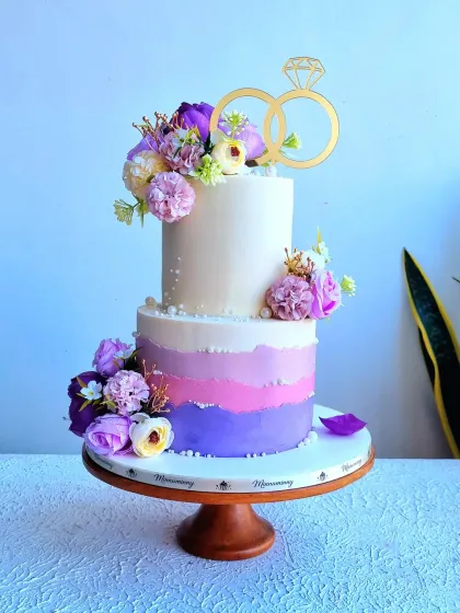 A full view of the purple ombre wedding cake on its stand.