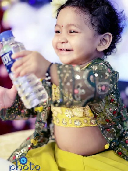 A candid, joyful photograph of the birthday girl smiling brightly while holding a water bottle. These unposed moments are often the most memorable.