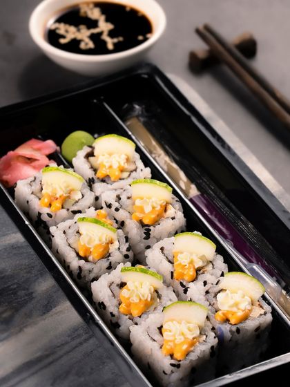 A box of eight Cucumber Cream Cheese rolls, packed and ready for delivery with wasabi and gari.