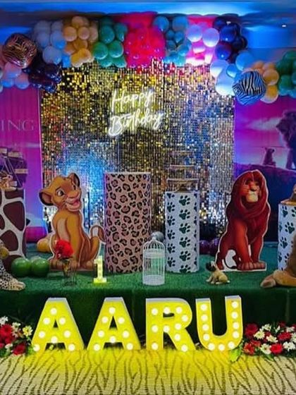 A colorful and exciting Lion King theme. The stage is set with a Pride Rock backdrop, character cutouts of Simba, and vibrant balloon arrangements to recreate the iconic movie scenes.