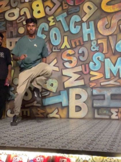 A still shot from a Red Bull Dance Your Style battle, capturing a moment of flow against a cool graffiti backdrop.