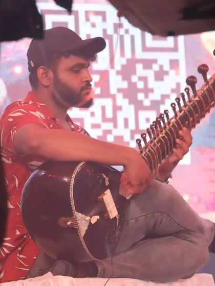 A side view of me playing at a modern event, with a QR code visible on the screen behind me. It's a great example of how ancient traditions meet today's technology.