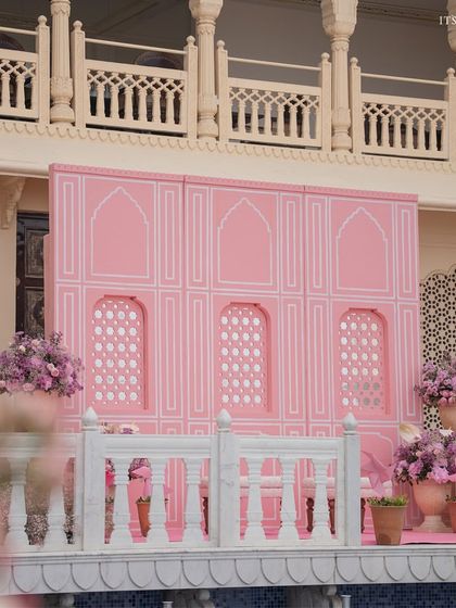 A view of the pink architectural elements and floral arrangements set against the beautiful facade of the Anantara Jaipur.