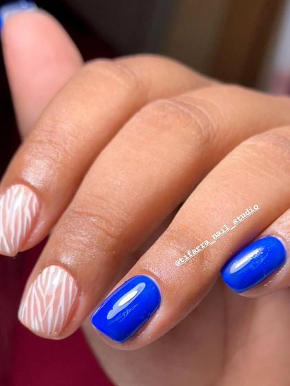 A close-up of the blue and zebra stripe nails, showing the clean application and fun design.