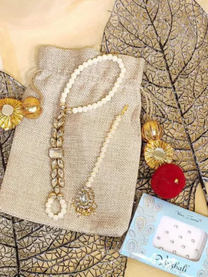 A beautiful Mehendi favour idea. This simple jute potli is filled with a delicate pearl and stone haath phool and a pack of bindis, making it a practical and pretty gift for your guests.