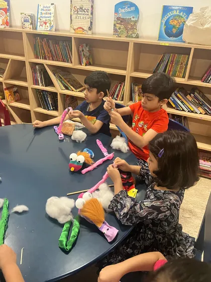 The boys are deep in concentration as they assemble their puppets. This part of the workshop requires focus and helps them practice their crafting skills.
