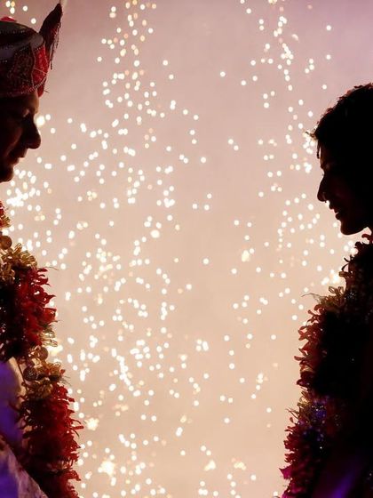 A dramatic silhouette of the bride and groom against a backdrop of fireworks. This technique creates a magical and celebratory image that is truly unforgettable.