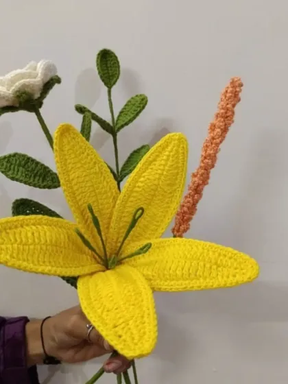 A vibrant yellow lily takes center stage in this beautiful crochet bouquet. Each petal is carefully shaped and stitched by our talented artisans.