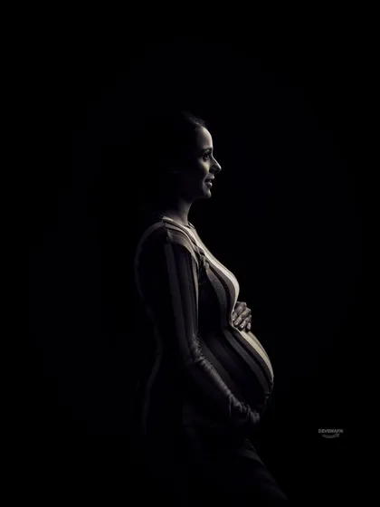 A silhouette portrait is a powerful way to focus on the beautiful shape of your baby bump. This artistic, low-key photography style creates a dramatic and timeless image that is both intimate and striking.