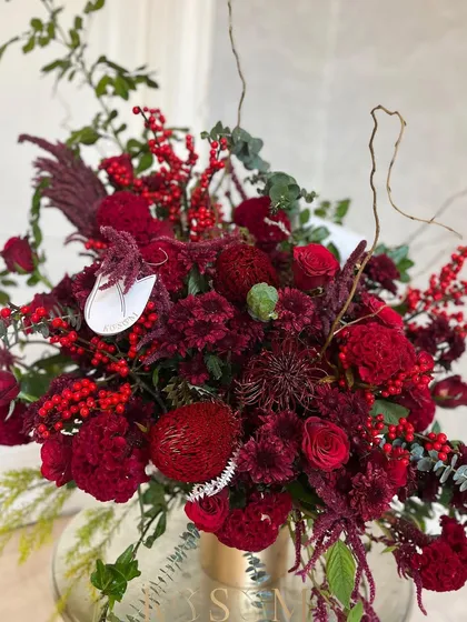 Another perspective on this observation in red. The combination of imported and local flowers creates a piece that is both globally inspired and deeply rooted.
