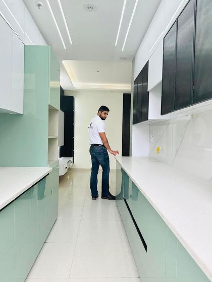 A look at the finished mint-green modular kitchen at Nirala Estate, showcasing the ample storage and clean, modern aesthetic.
