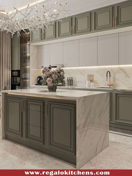 This kitchen is the epitome of classic luxury, featuring olive-green paneled cabinets and a stunning marble island and backsplash. The ornate chandelier adds a touch of glamour, creating a space that feels both grand and welcoming.
