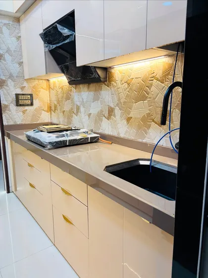 The textured backsplash in this kitchen adds a unique, tactile element. I used high-gloss beige cabinets and a modern black chimney to complete the look.