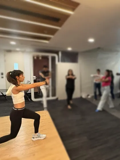 Demonstrating a lunge during a wellness workshop. Proper form is key to preventing injury and getting the most out of every movement.