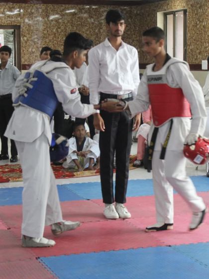 Respect before the fight. Two competitors shake hands before their match at the Warriors Cup, showing the sportsmanship that is central to Taekwondo.