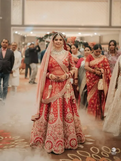 The bride's grand entrance, looking confident and beautiful. The makeup is set to be picture-perfect from every angle, even amidst the celebratory smoke and lights.