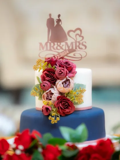 A client's photo of the navy and burgundy wedding cake. I love how the colors pop against the red roses on the table.