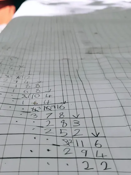 A close-up of the meticulous calculations involved in a massive long division problem. The child is not just finding an answer; she is exploring the process, checking her work, and experiencing the deep satisfaction of sustained focus.