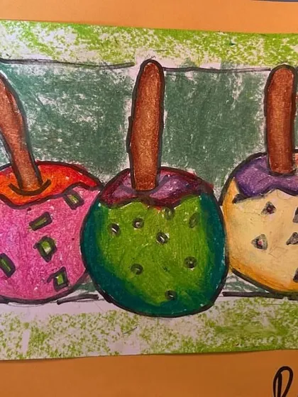 This version of the candy apples uses oil pastels, creating a soft, textured look. We encourage students to explore different art materials.