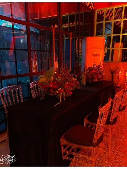 The seating for the dinner was kept dark and elegant, with transparent ghost chairs that didn't distract from the dramatic red lighting and rich floral centerpieces.