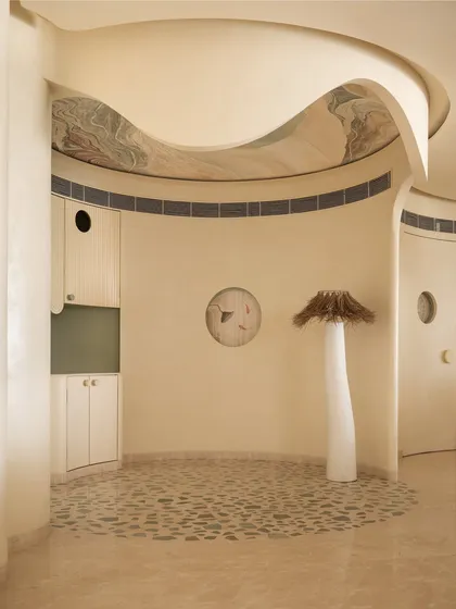This coffee corner is an ode to our client's love for coffee. The floor features quartzite chips inlaid in a terrazzo pattern, while a sculptural floor lamp and art on the ceiling complete this unique, cozy nook.