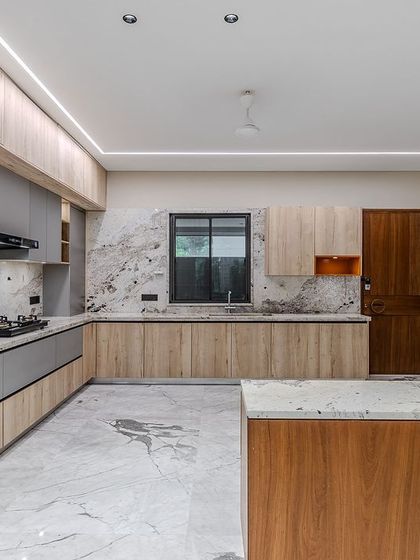This angle shows the handleless design and the mix of materials, including wood, lacquer, and a special copper-toned glass pantry, creating a rich, textured palette.