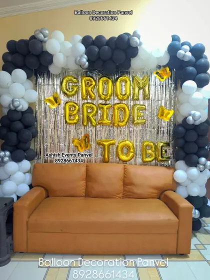 A 'Groom to be Bride to be' decoration in a chic black, white, and gold color scheme. The balloon arch and foil letters create a perfect photo spot for the happy couple.