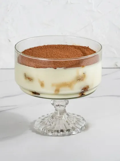 A single serving of my Classic Tiramisu in a dessert glass, showcasing its clean layers and cocoa-dusted top.
