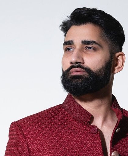 A close portrait shot of the crimson bandhgala, emphasizing the mandarin collar and the fabric's intricate weave. This jacket is designed to look exceptional both from a distance and up close.