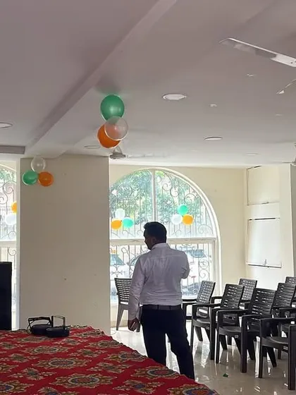 A simple indoor event setup with a basic stage, DJ console, and speakers, suitable for corporate events, conferences, or small parties.