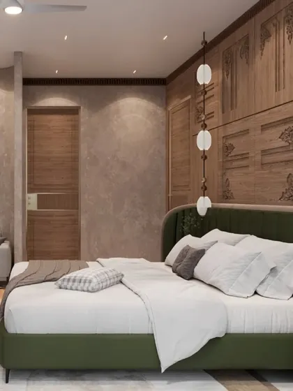This luxurious bedroom features intricately carved wooden paneling as a headboard wall, creating a blend of modern design and timeless charm. An olive green bed and a small seating area complete this sanctuary of comfort.