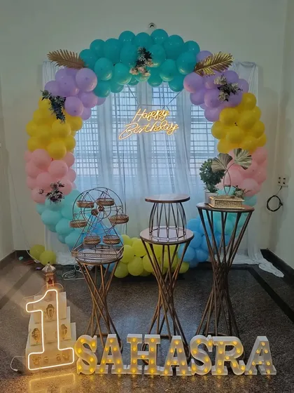 Another angle of the first birthday setup for Sahasra. This view shows how the light-up name and number integrate seamlessly with the pastel-colored balloon ring and decorative stands.