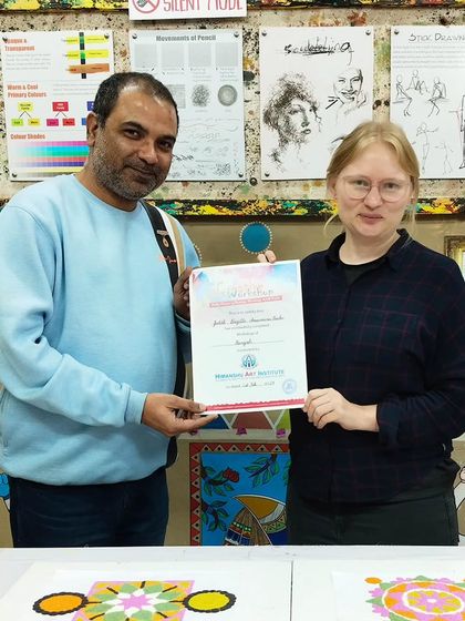 An international student receiving her certificate after completing a Rangoli making workshop. Our institute welcomes art lovers from all over the world.