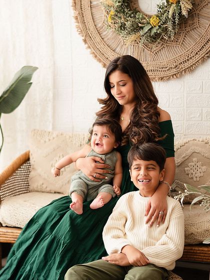 A joyful family photo with mom, big brother, and the baby all laughing together.