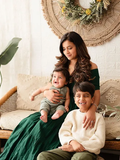 A joyful family photo with mom, big brother, and the baby all laughing together.