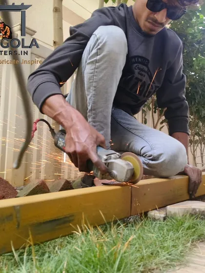 A member of our team carefully grinds a metal beam, ensuring a smooth surface before painting and installation. This attention to detail in the preparation phase is crucial for achieving a flawless and durable final product.