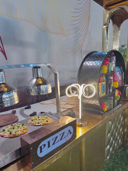 A close-up of the live pizza station, where fresh pizzas are prepared and kept warm under heat lamps.
