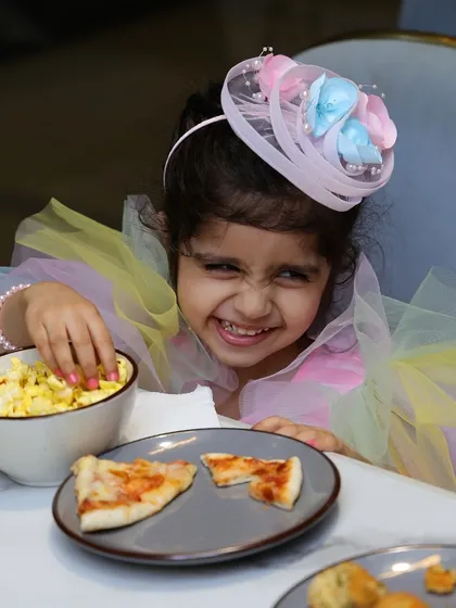 This is what pure birthday joy looks like. Dressed in her unicorn best, this little one is happily digging into some popcorn and pizza at her party. We love seeing these priceless smiles at our cafe.