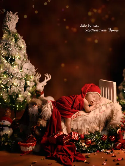 A wide shot of the elaborate Christmas setup, showing the sleeping newborn, a lit-up tree, and plenty of festive props.