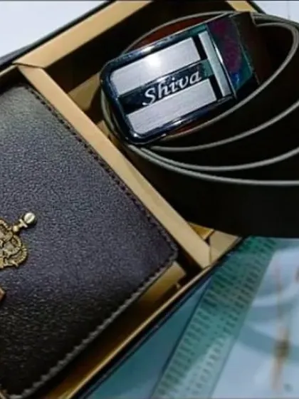 This combo set features a personalized brown leather wallet with a crown charm and a matching leather belt with the name engraved on the buckle.
