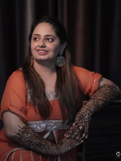 A portrait of the bride showcasing her elaborate and beautiful Mehandi design covering her arms.