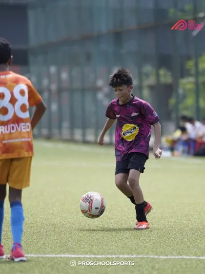 A young player dribbles with confidence, looking for a teammate to pass to.