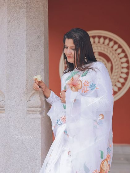 A series of peaceful portraits taken at a temple. The model's white saree contrasts beautifully with the intricate stone architecture, creating a sense of calm and serenity.