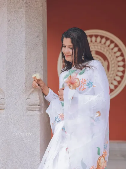 Another angle from the white saree series, this shot captures a moment of quiet contemplation.