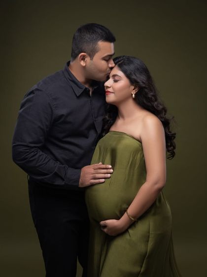 A quiet, tender moment. His hand on her bump and a gentle kiss on her head speak volumes in this beautiful olive green themed portrait.