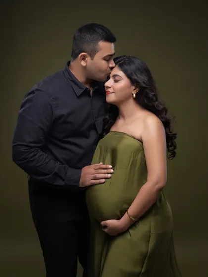 A quiet, tender moment. His hand on her bump and a gentle kiss on her head speak volumes in this beautiful olive green themed portrait.