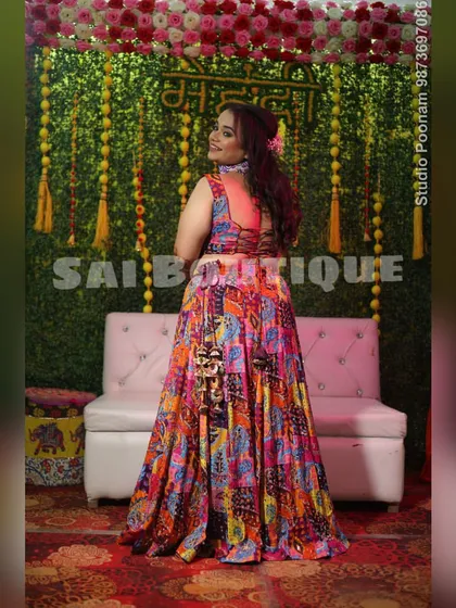 The bride looking stunning in a multi-colored printed lehenga for her Mehndi. The back of the blouse has a beautiful tie-up detail.