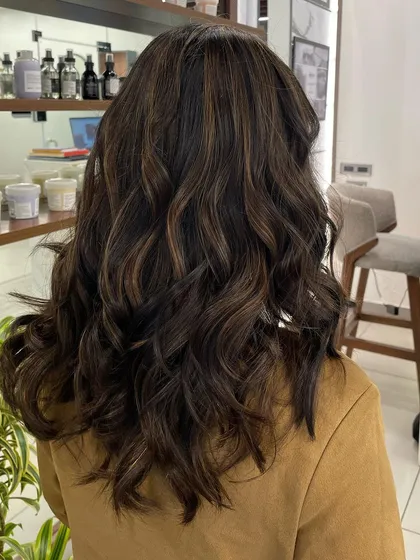 This brownie hair color has subtle, warm highlights woven through it. The result is a natural look that is full of dimension.