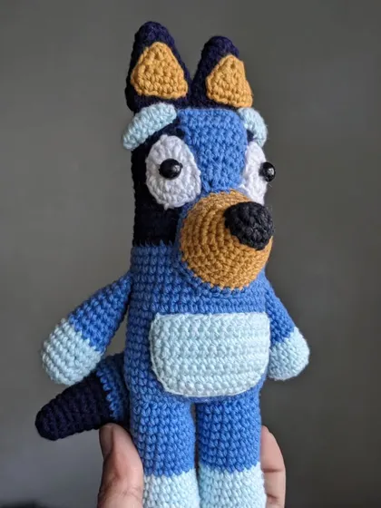 A side view of the full Bluey doll.